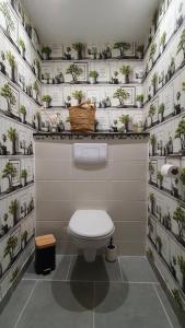 a bathroom with a toilet and plants on the wall at Studio Lindois in Lalinde