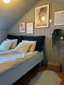 uma cama num quarto com fotografias na parede em The View Guesthouse at Ekeberg -10 min by tram to Oslo S em Oslo