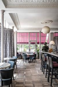 a dining room with tables and chairs and pink windows at York & Albany in London