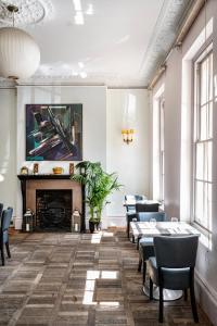 a room with tables and chairs and a fireplace at York & Albany in London