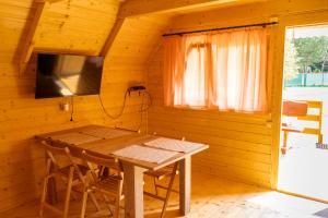 a dining room with a table and chairs in a cabin at Nad Strumykiem in Sasino