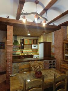 cocina con mesa de madera y nevera en CASA RURAL CURTIDORES, en El Batán