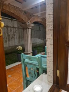 a blue chair sitting on a patio with an archway at Casa Miranda in Antigua Guatemala