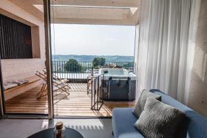 ein Wohnzimmer mit einem blauen Sofa und einem Balkon in der Unterkunft Stock & Stein Lodges in Bad Gleichenberg