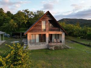 a small house with a deck on a field at Shemoqmedi chalet 