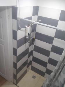 a shower with a black and white checkered wall at Bluci seksti in Seksti