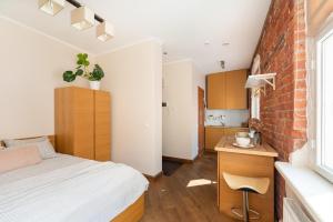 a bedroom with a bed and a brick wall at Rüütli Apartments in Tartu Old Town in Tartu