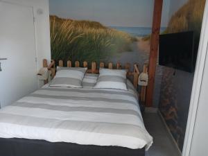 una camera da letto con un letto e un dipinto sul muro di GOUEL-BRAS a Sarzeau