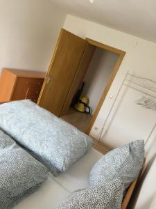 1 dormitorio con 1 cama con puerta y almohadas en FeWo Tannerbauer en Regen