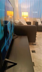 a living room with a couch and a flat screen tv at Hotel Exclusive in Riccione