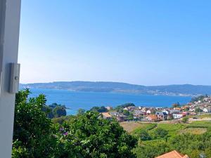 a view of a town and a body of water at El Mirador de playa LAPAMAN - BUEU in Marín +32 photos