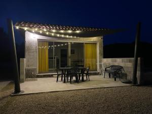 a patio with a table and chairs and lights at ( Mine de rien ) in Grambois