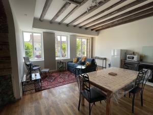 a living room with a table and a couch at Résidence Les Cépages in Saint-Jean-de-Vaux