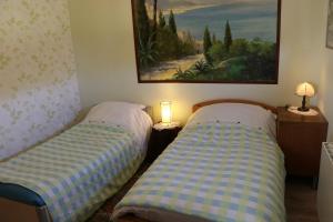 2 camas en una habitación con un cuadro en la pared en Gite les Gouleries chez Dominique, en Dangy