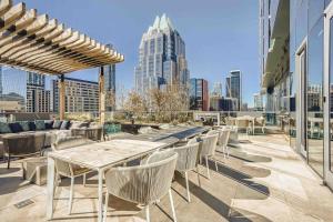 a patio with tables and chairs and a city skyline at Downtown Austin Oasis Luxurious Studio Retreat with amazing Pool and Gym in Austin