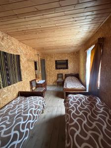 Tusheti的住宿－Shio's Stonehouse in Tusheti，客房设有两张床和木制天花板。