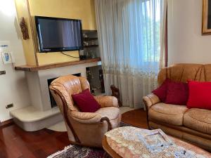 uma sala de estar com 2 cadeiras e uma televisão de ecrã plano em B&B Michela em Baronissi