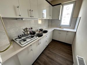 a white kitchen with a stove and a window at THE SUİT Residence in Nevsehir
