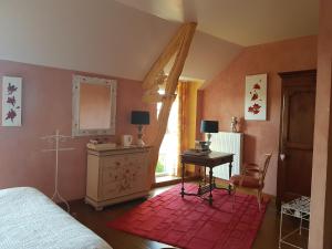 um quarto com uma cama, uma secretária e uma janela em Chambres d'Hôtes Les Châtelains em Ennordres