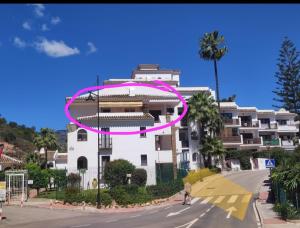 un edificio con un cerchio rosa sopra, vicino a una strada di Comfortable one bedroom apartment a Fuengirola