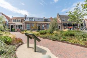 un bâtiment avec un banc au milieu d'un jardin dans l'établissement Fika, à Renesse