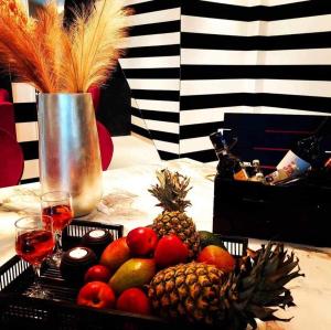 un vassoio di frutta su un tavolo con bicchieri di vino di Mary's Luxury Apartment a Agria