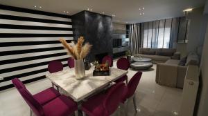 un soggiorno con tavolo e sedie viola di Mary's Luxury Apartment a Agria