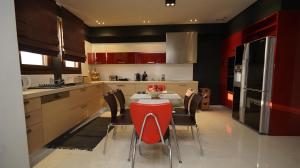 a kitchen with a table and red chairs in a kitchen at Mary's Luxury Apartment in Agria