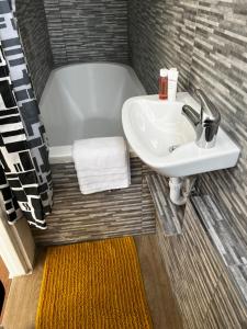 een badkamer met een wastafel en een bad bij Brand new cosy studio apartment in West Dulwich