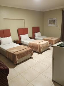 um quarto de hotel com três camas num quarto em ورده em Al Khobar