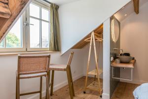 um quarto com uma escada, uma mesa e cadeiras em Fika em Renesse
