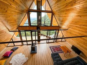 una cabaña de madera con vistas panorámicas a la sala de estar. en BULUT BUNGALOW, en Akcaabat