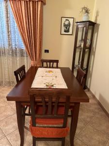 a wooden dining room table with two chairs and a window at B&B Pram'e Sinis in Càbras