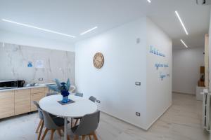 a white kitchen with a white table and chairs at B&B BISCEGLIE in Bisceglie