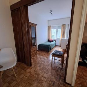 una camera con una camera da letto, un letto e uno specchio di Parque Villa Biarritz a Montevideo