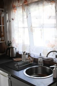 encimera de cocina con fregadero y ventana en Margarita's cottage, en Jūrmala