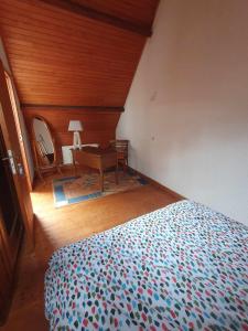 a bedroom with a bed and a table and a mirror at Gite des 3 Cailloux in Leulinghen-Bernes