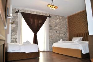 a bedroom with two beds and a window at Boutique Vila FIDANI in Voskopojë