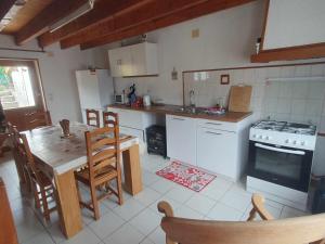 a kitchen with a table and a stove top oven at Gite des 3 Cailloux in Leulinghen-Bernes