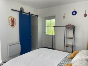 Un dormitorio con una puerta azul y una cama en Venez Vernou, 