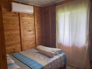 Habitación pequeña con cama y ventana en La Mochis, en Puerto Jiménez