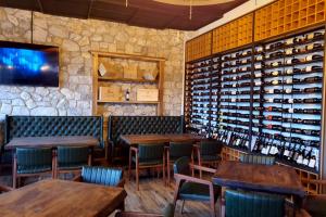 a restaurant with wooden tables and wine bottles at Boutique Vila FIDANI in Voskopojë