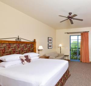 1 dormitorio con 1 cama grande y ventilador de techo en Lodge On The Desert en Tucson