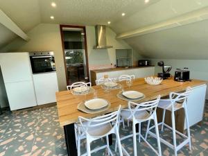a kitchen with a wooden table and white chairs at Gite Pays de Herve - Emeraude in Battice