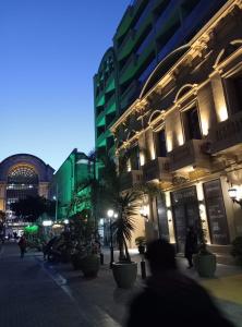 a city street at night with buildings and a palm tree at Carlos Gardel Tango Studio in Buenos Aires