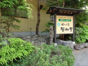 a sign in front of a building with trees at Natsukashiya Fuwari in Nikko