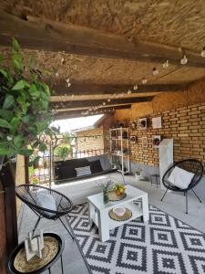 a patio with a table and chairs and a couch at Vikendica pod kulom in Vršac