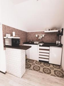 a kitchen with white appliances and a tile wall at Vikendica pod kulom in Vršac