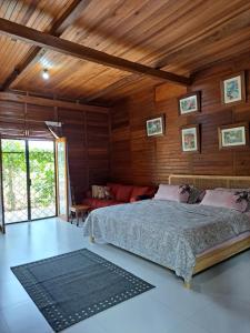 um quarto com uma cama num quarto com paredes de madeira em Juar House em Simpen