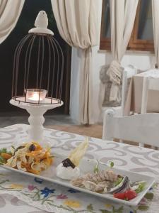 Hotel Calvanella في سيستولا: طبق من الطعام على طاولة مع قفص الطيور